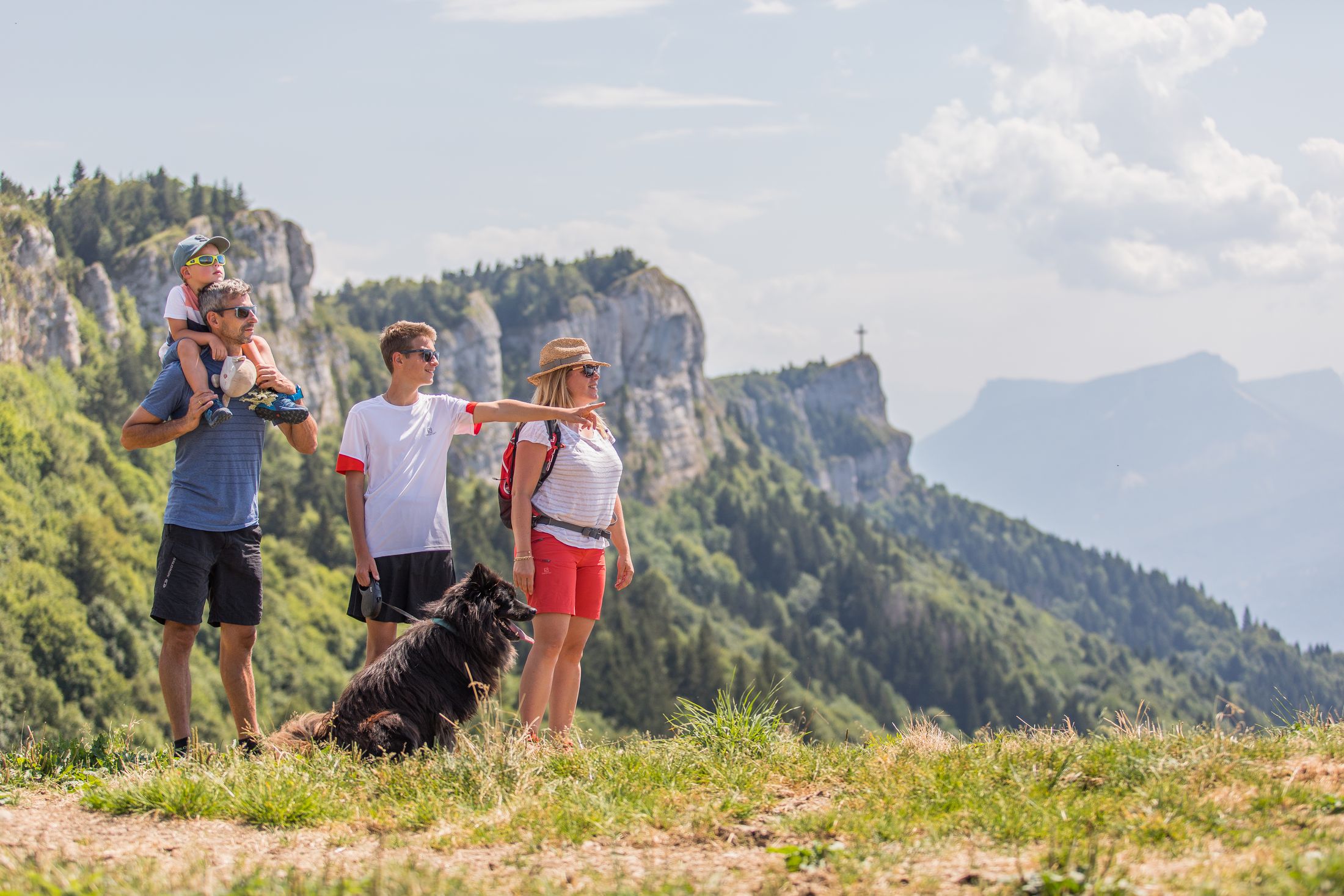 Une famille en randonnée contemple la vue depuis Les Belledonnes 