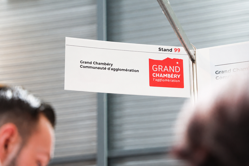 Panneau d'un stand sur un salon professionnel sur lequel on peut lire Grand Chambéry communauté d'agglomération.