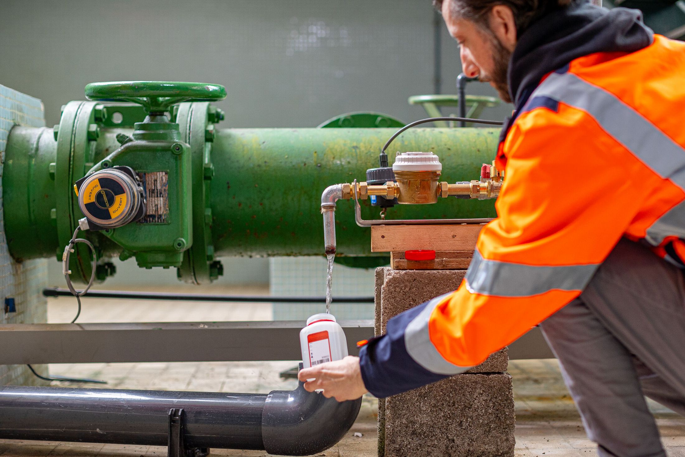 Agent qui effectue un prélèvement d'eau 