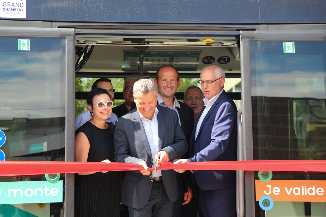 Des élus coupent un ruban inaugural pour le nouveau bus au biogaz. 